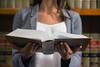 a woman with a book open in her hands